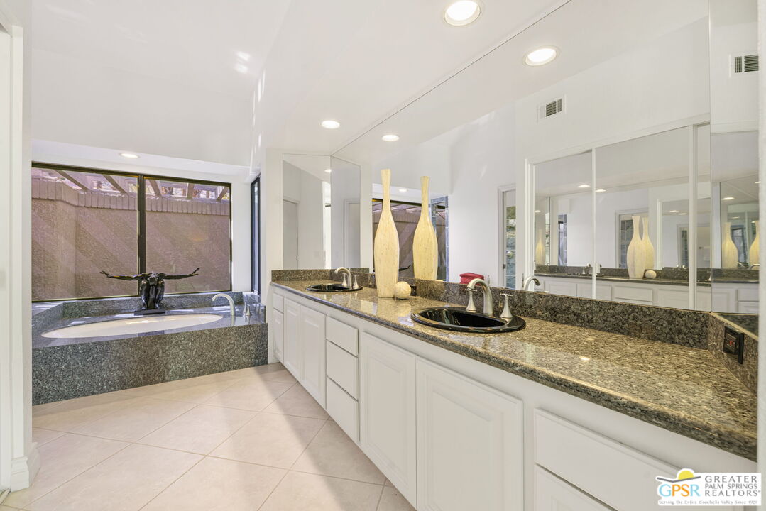 8 Alta Vista Rancho Mirage, CA 92270 - Photo 40 of 46 a large bathroom with a granite countertop double vanity sink a bathtub and window