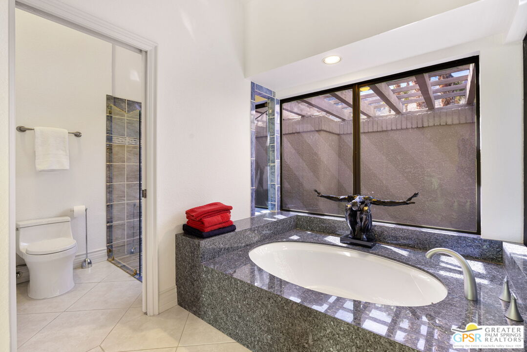 8 Alta Vista Rancho Mirage, CA 92270 - Photo 41 of 46 a bathroom with a granite countertop sink and a mirror