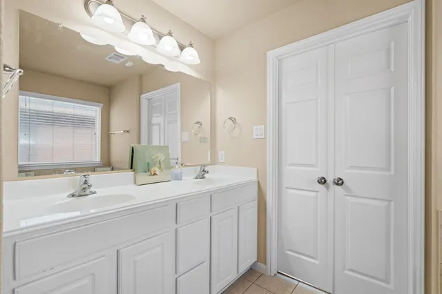 a bathroom with a double vanity sink and a mirror