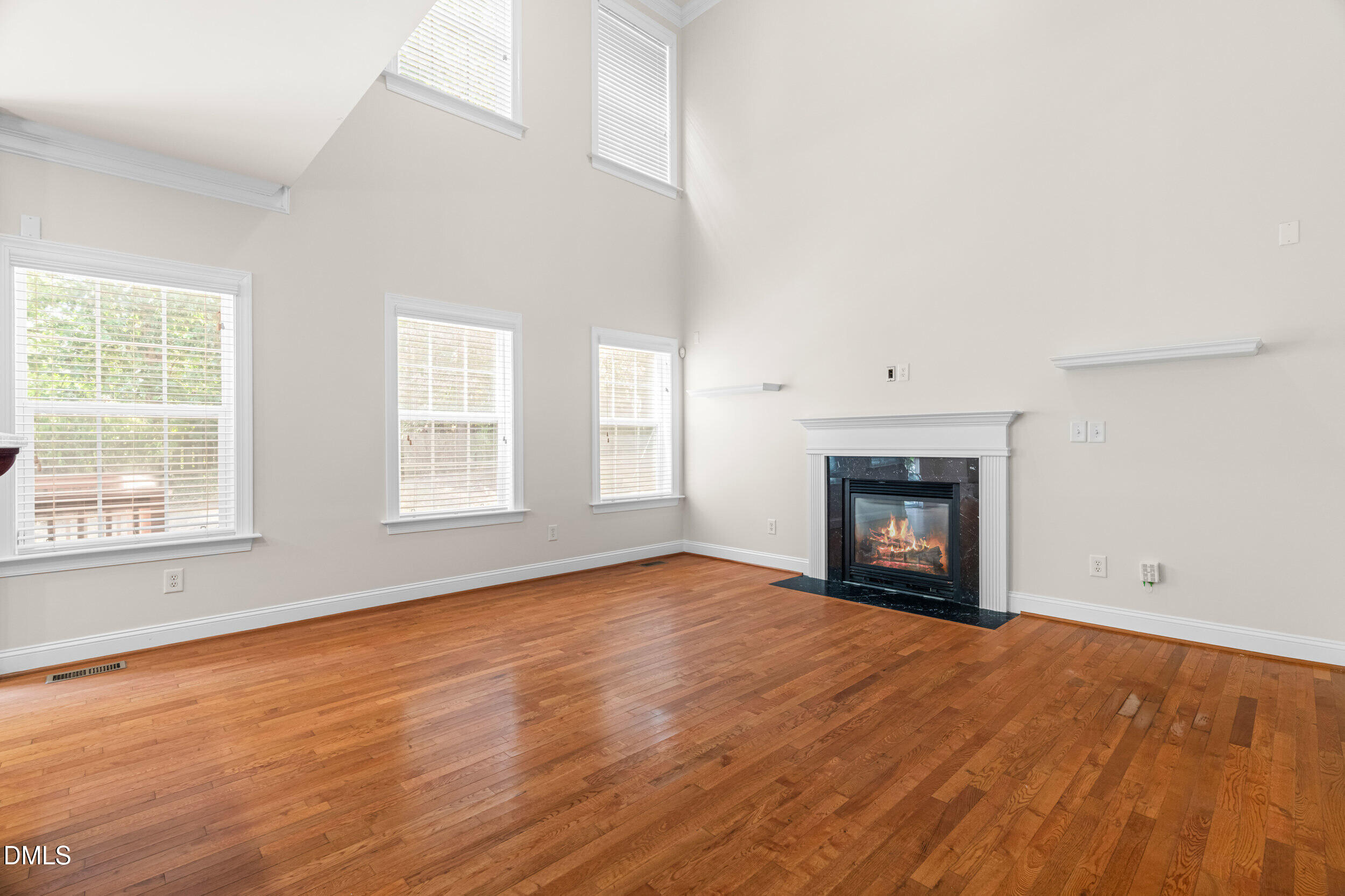 5708 Catskill Court Durham, NC 27713 - Photo 14 of 39 an empty room with wooden floor fireplace and windows