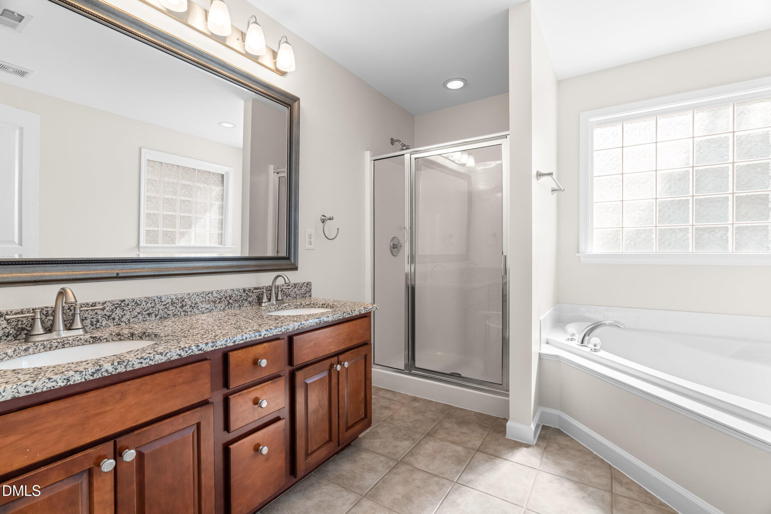 5708 Catskill Court Durham, NC 27713 - Photo 28 of 39 a bathroom with a tub a sink and a mirror
