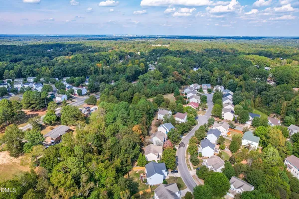 an aerial view of a houses with a yard and green space