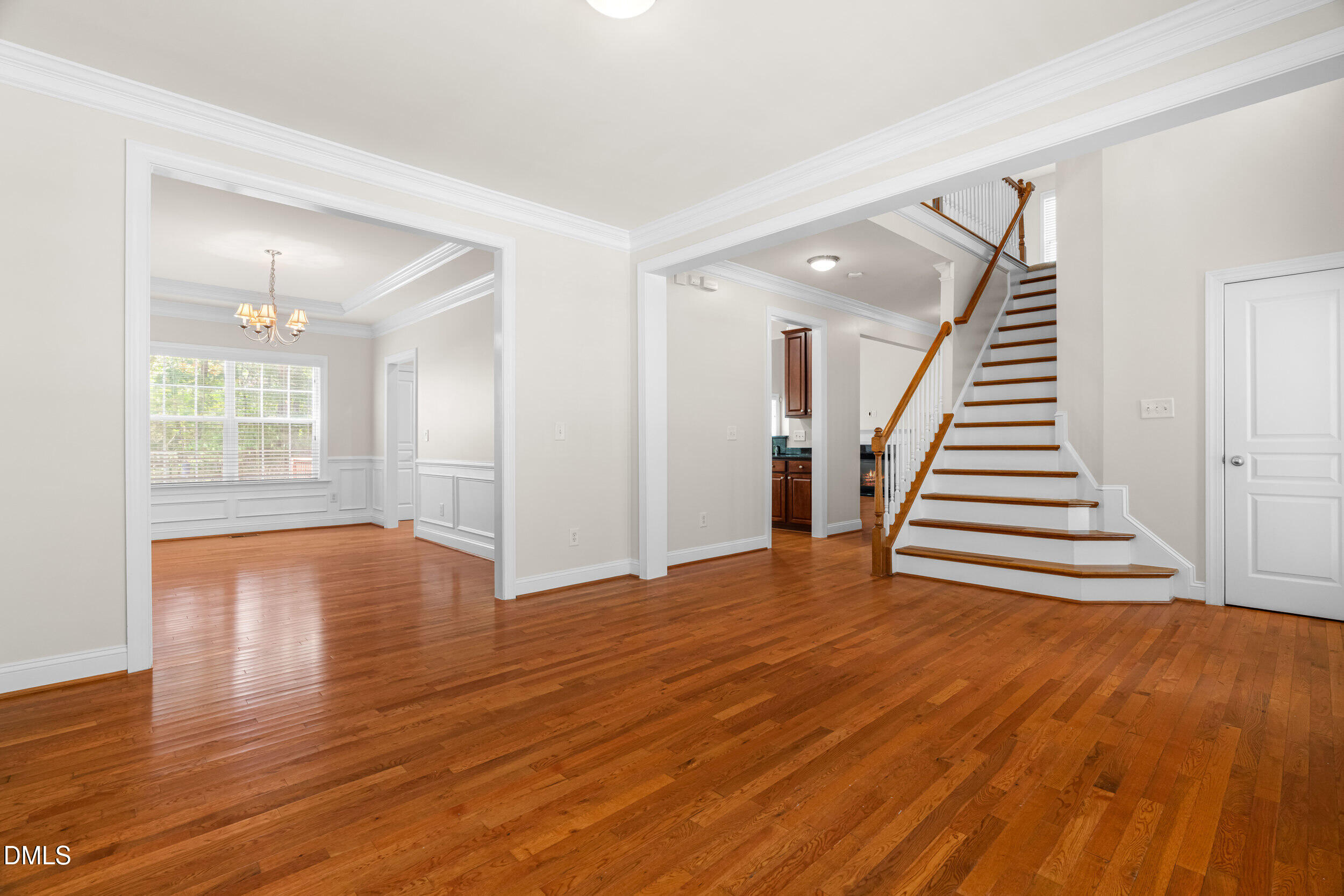 5708 Catskill Court Durham, NC 27713 - Photo 7 of 39 a view of an empty room with wooden floor and stairs