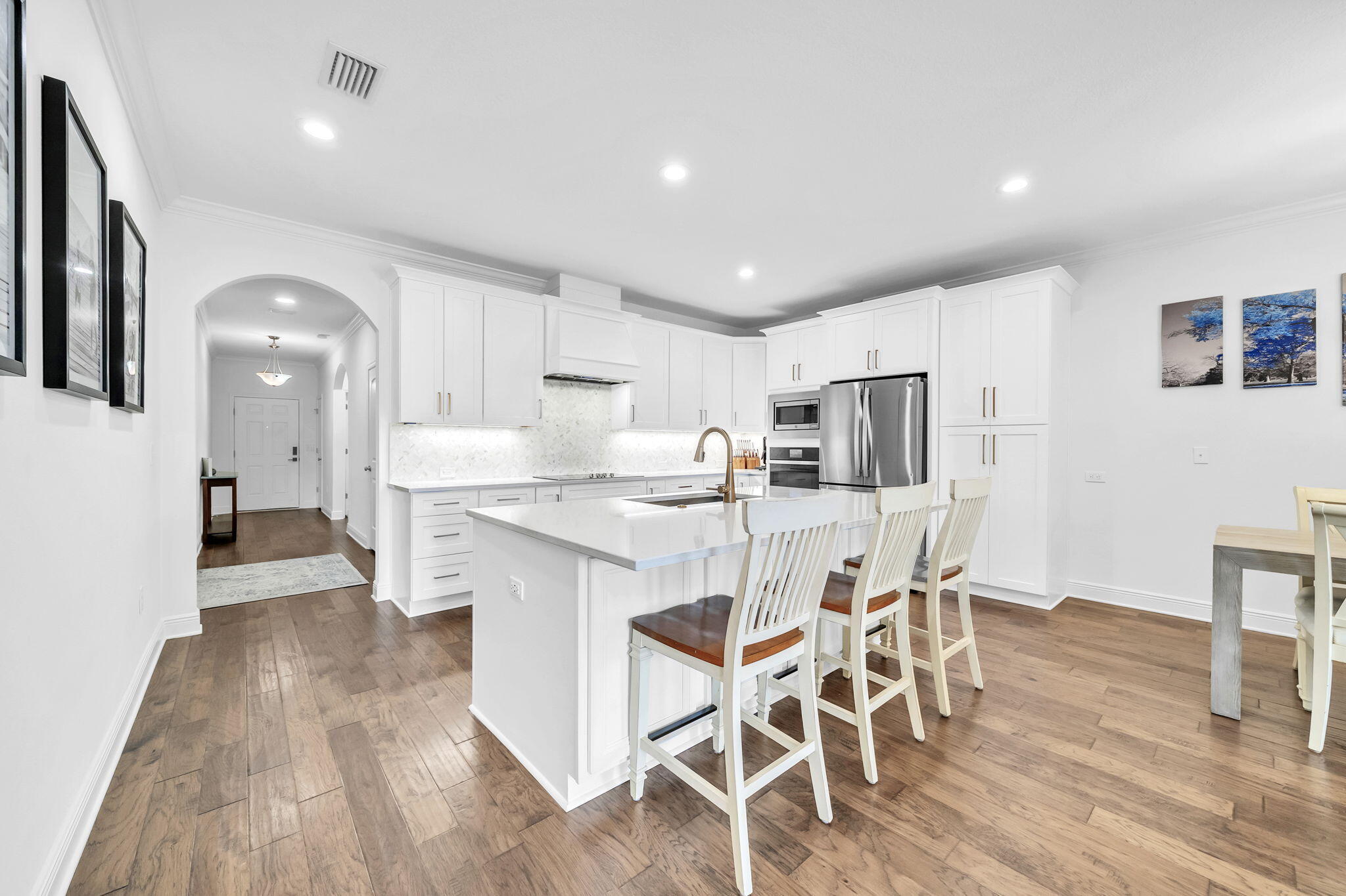 106 Mary Ellen Way Freeport, FL 32439 - Photo 11 of 79 a kitchen with stainless steel appliances a dining table chairs and wooden floor