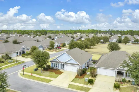 a view of a hallway with wooden floor and a chandelier