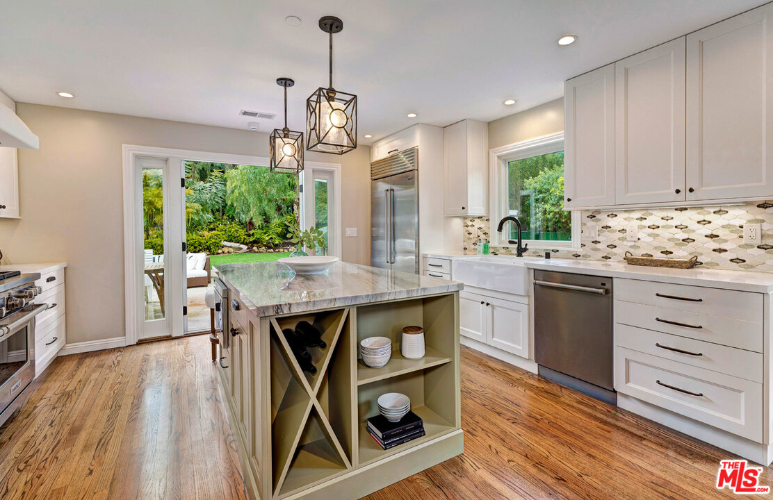 20779 Big Rock Drive Malibu, CA 90265 - Photo 13 of 37 a kitchen with stainless steel appliances granite countertop a stove a sink dishwasher and a wooden floor