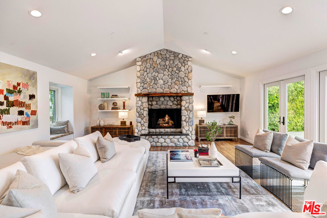 20779 Big Rock Drive Malibu, CA 90265 - Photo 9 of 37 a living room with furniture a large window and a fireplace