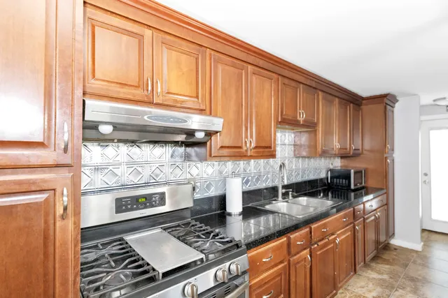 a kitchen with stainless steel appliances granite countertop a stove and a sink