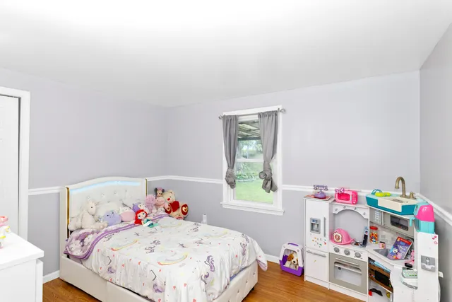 a bedroom with a bed dresser and a window