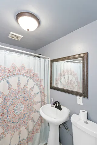 a bathroom with a sink mirror and a toilet