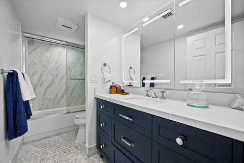 a bedroom with a bed and a dresser next to a window