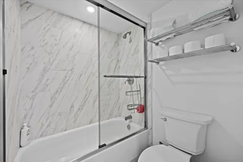 a bedroom with a bed and a flat tv screen next to a window