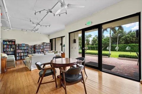 a large white kitchen with a lot of counter space and wooden floor