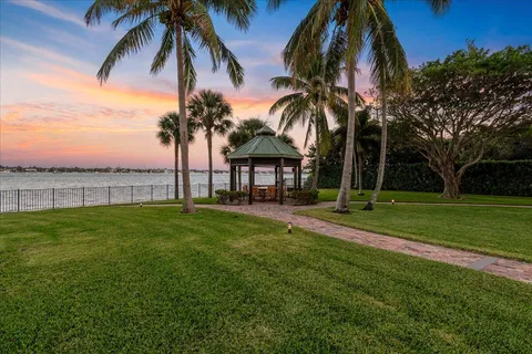 a dining room with wooden floor a chandelier a glass table and chairs
