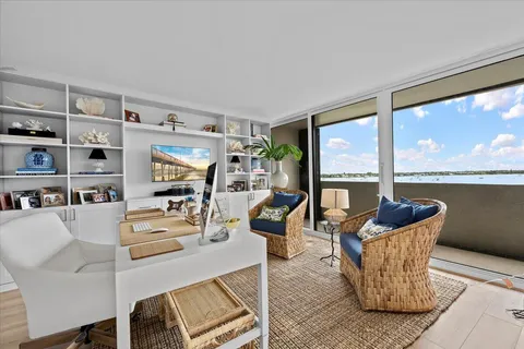a living room with furniture floor to ceiling window and wooden floor