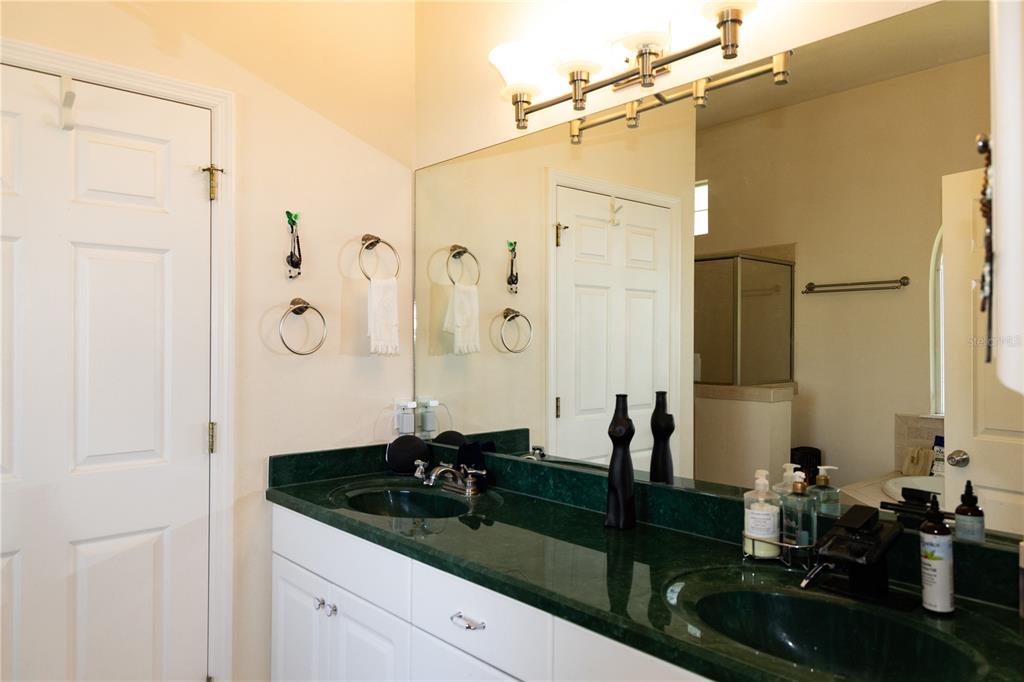 6494 Northwest 109th Place Alachua, FL 32615 - Photo 13 of 19 a bathroom with a double vanity sink mirror and shower