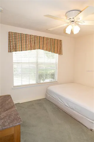 a bed sitting in a bedroom next to a window