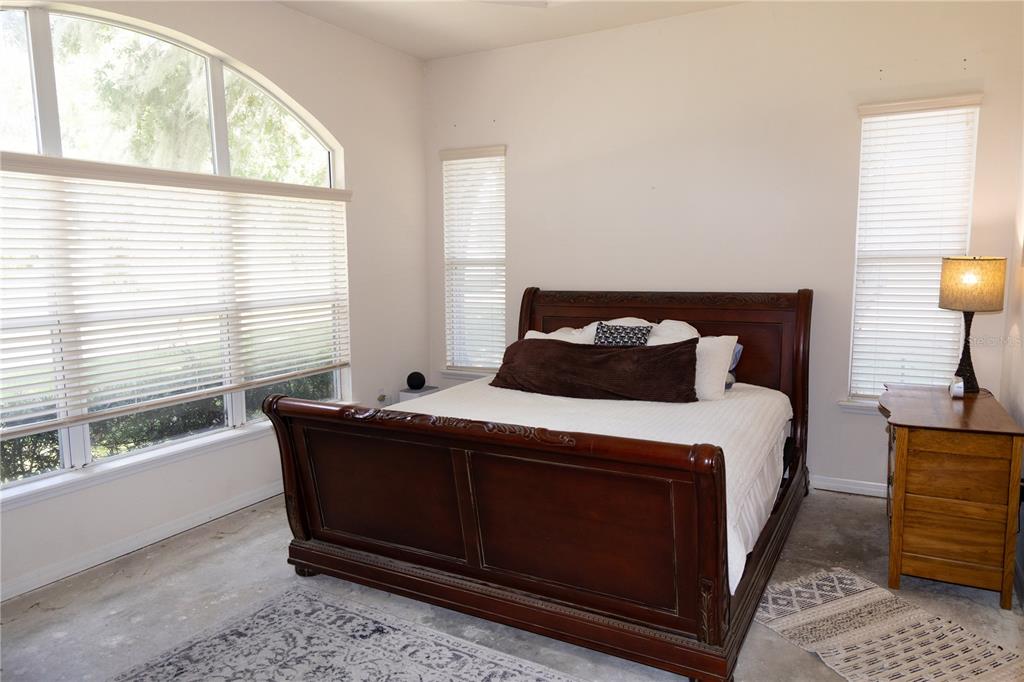 6494 Northwest 109th Place Alachua, FL 32615 - Photo 10 of 19 a bedroom with a bed and wooden floor
