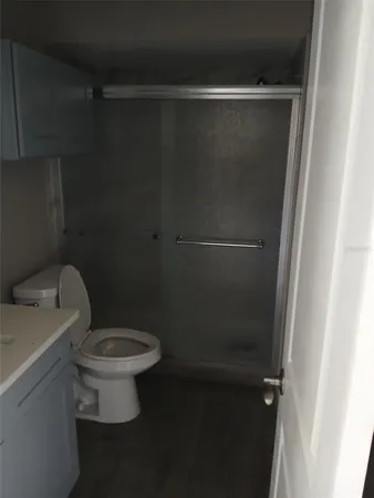 a white toilet sitting next to a shower