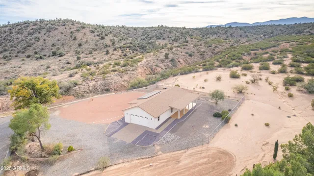 a view of a dry yard with mountains in the background
