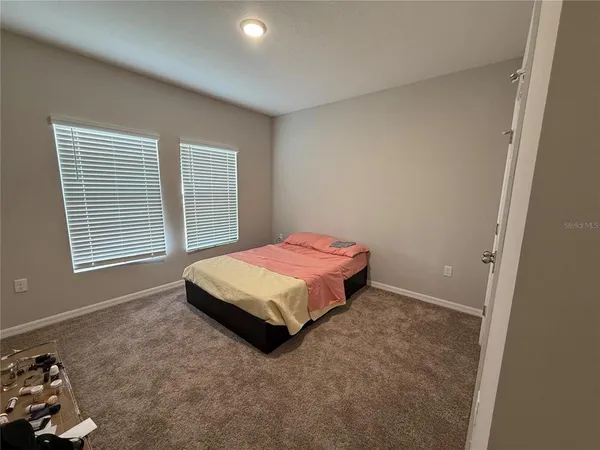 a spacious bedroom with a bed and a window