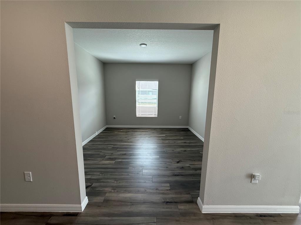 3464 Dahlia Drive Haines City, FL 33844 - Photo 14 of 41 a view of empty room with window and wooden floor
