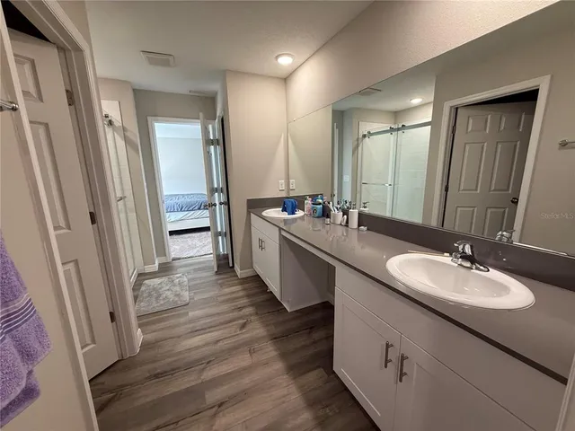 a bathroom with a double vanity sink a mirror and a shower
