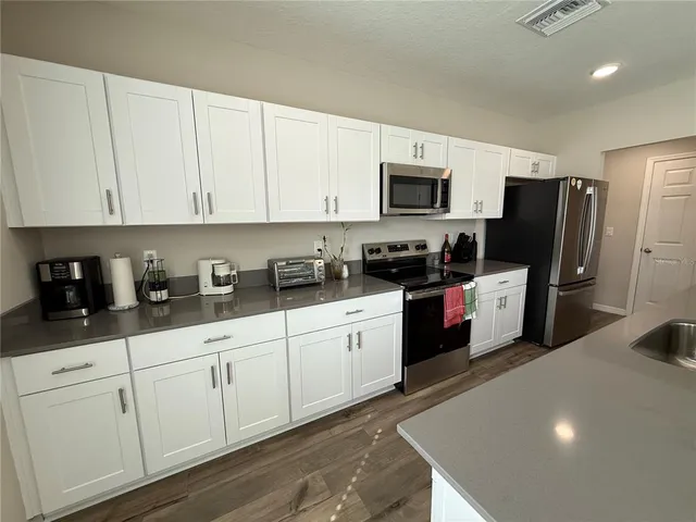 a kitchen with a refrigerator and a stove top oven