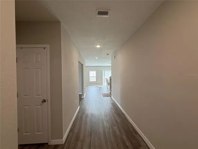 a view of a hallway with wooden floor