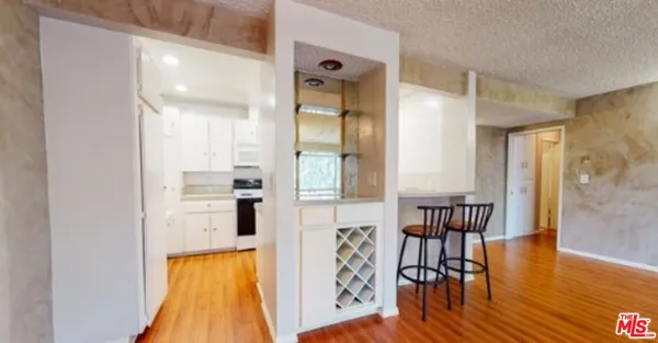 a view of a hallway with dining room and wooden floor