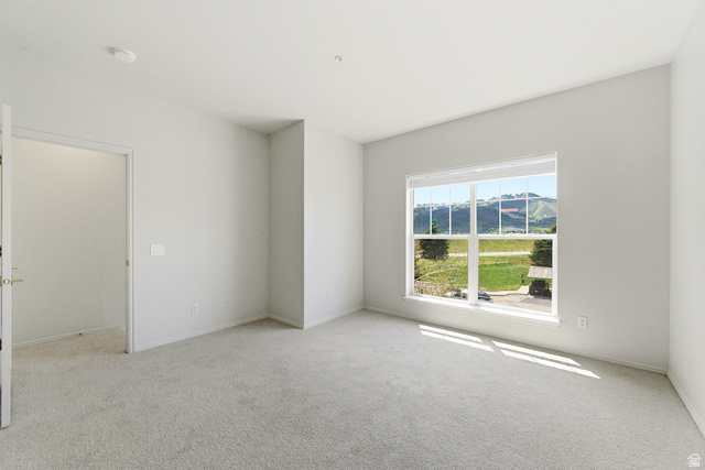 900 Bitner Road, Unit P20 Park City, UT 84098 - Photo 23 of 42 Spacious room featuring neutral carpeting, light-toned walls, and a large window with a mountain backdrop