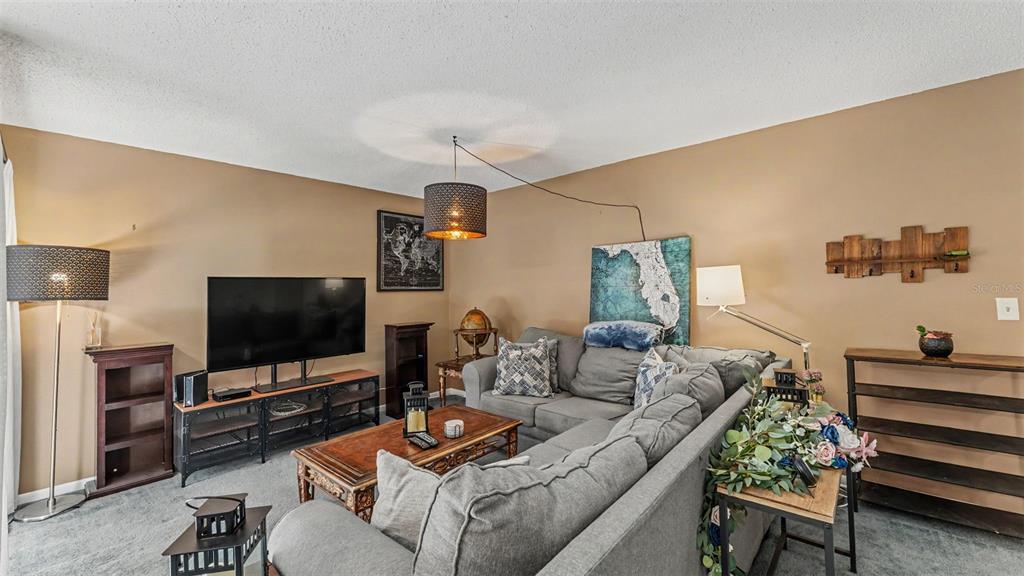 2025 Sylvester Road, Unit N305 Lakeland, FL 33803 - Photo 9 of 34 a living room with furniture and a flat screen tv
