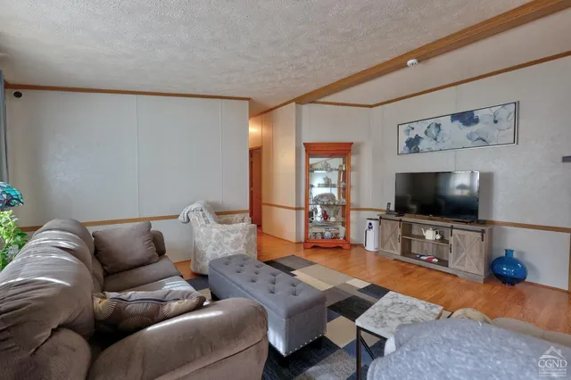 a view of a white house with a yard and sitting area