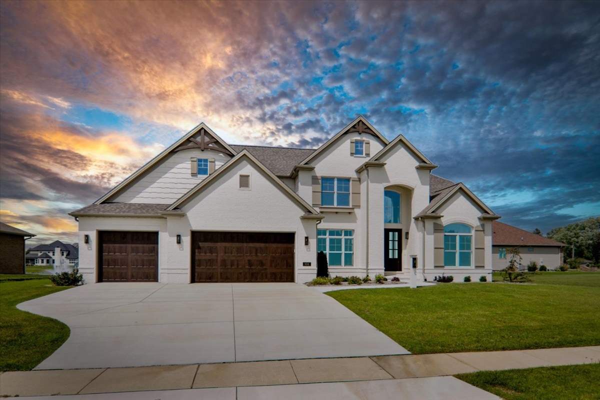 a front view of a house with a garden and yard