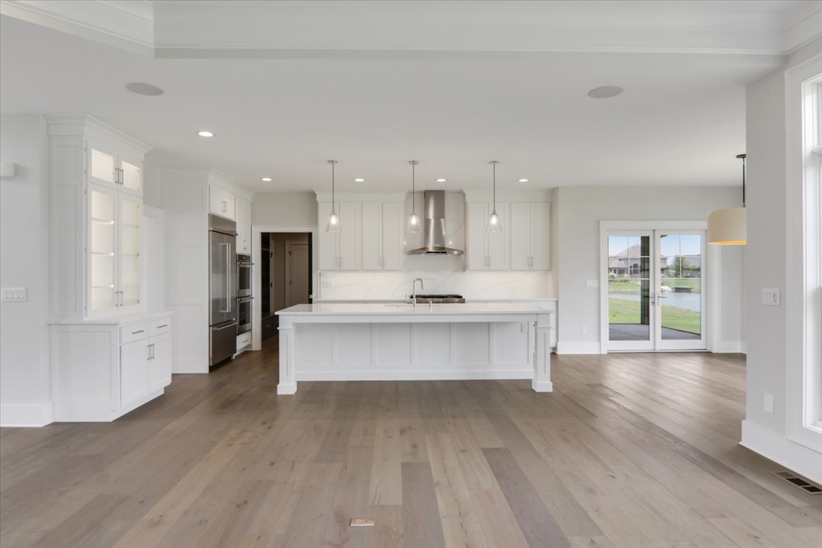 604 Cayman Way Savoy, IL 61874 - Photo 13 of 82 a large kitchen with stainless steel appliances cabinets a wooden floor and a sink