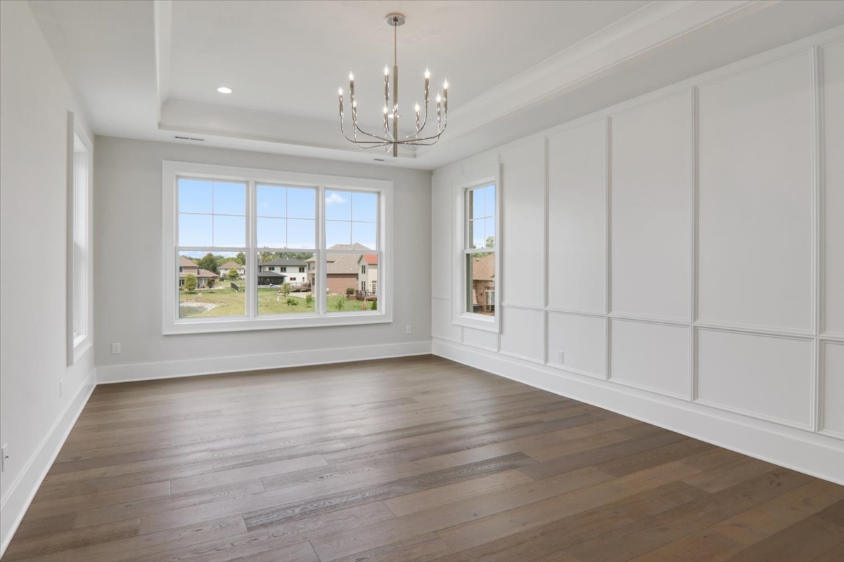 604 Cayman Way Savoy, IL 61874 - Photo 28 of 82 an empty room with wooden floor chandelier and windows
