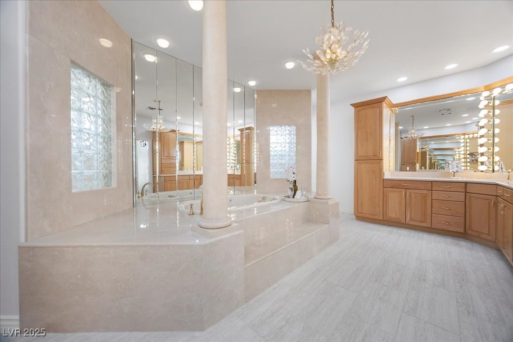 640 Quail Covey Road Henderson, NV 89002 - Photo 17 of 75 Full bath with a chandelier, a jaquzzi bath, vanity, decorative columns, and recessed lighting