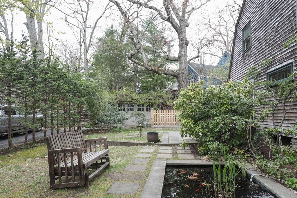 16 Percy Road Lexington, MA 02421 - Photo 6 of 31 a view of a chair and tables in the patio next to a lake