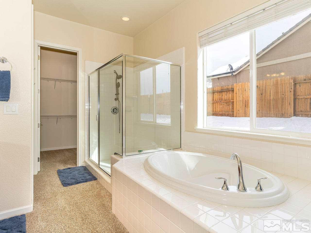 10175 Gold Mine Drive Reno, NV 89521 - Photo 13 of 24 a bathroom with a tub a window and a shower