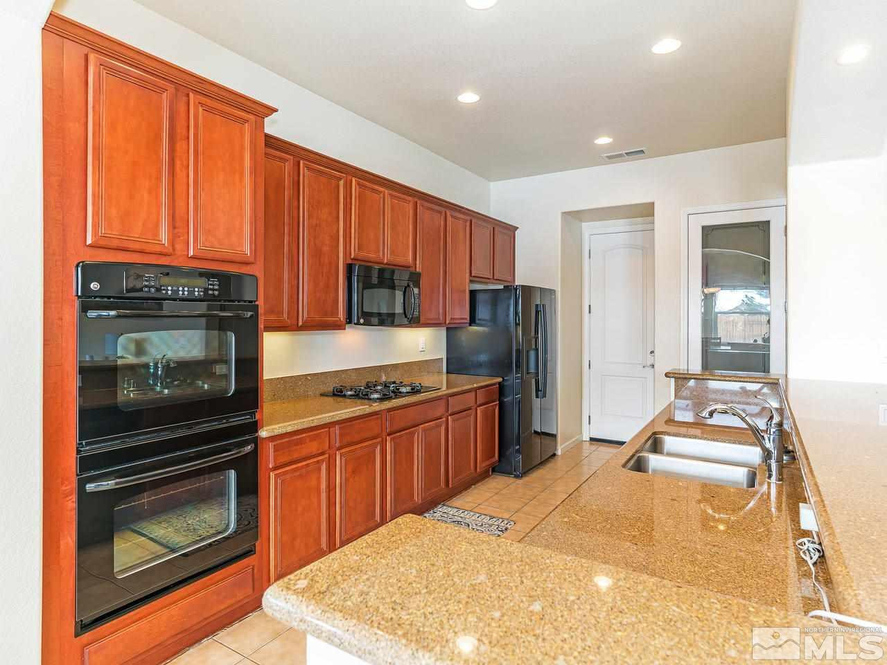10175 Gold Mine Drive Reno, NV 89521 - Photo 8 of 24 a kitchen with stainless steel appliances granite countertop a stove a refrigerator and a sink with granite countertops