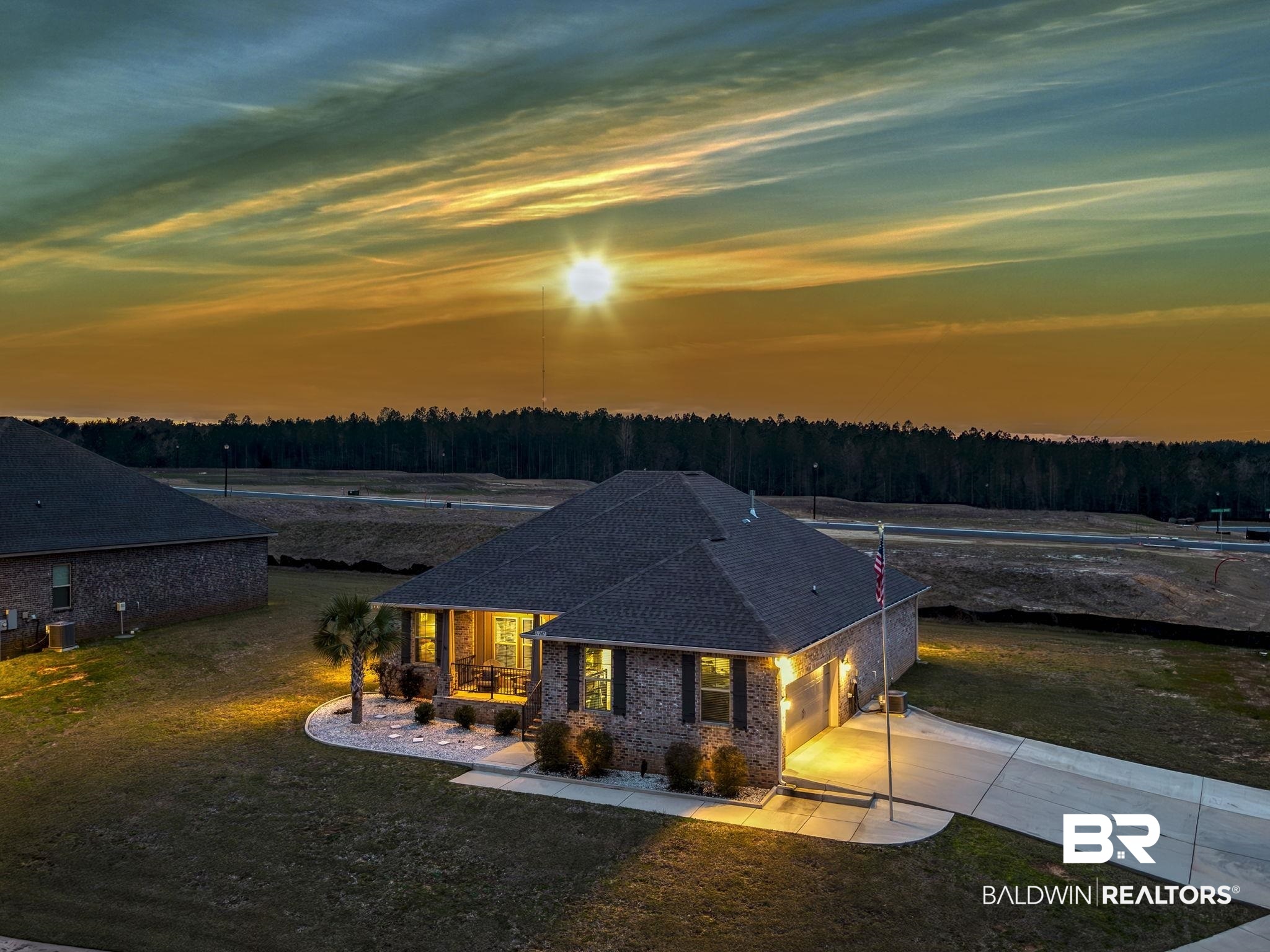 11247 Thistledown Loop Spanish Fort, AL 36527 - Photo 1 of 72 View of front facade with covered porch, a shingled roof, concrete driveway, a lawn, and a forest view