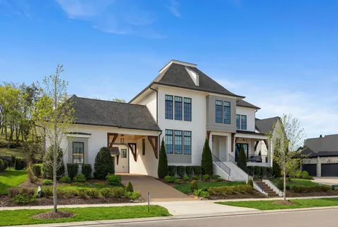a view of a hallway with wooden floor and a dining room
