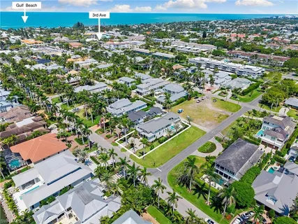 an aerial view of residential houses with outdoor space and trees