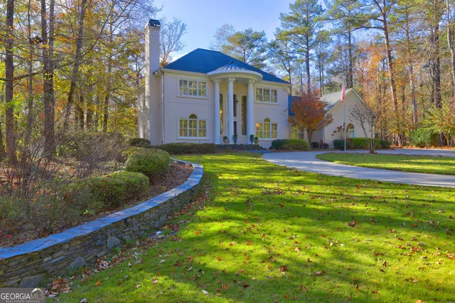 a view of swimming pool with large trees and wooden fence
