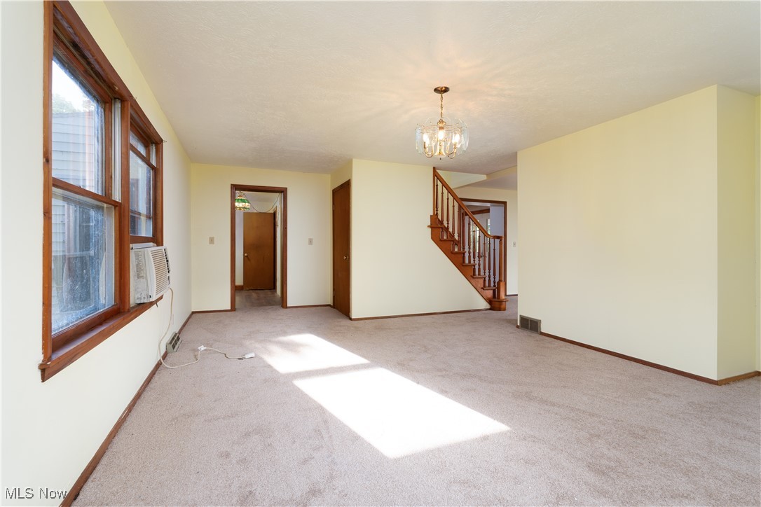 4491 Fox Road Kingsville, OH 44048 - Photo 8 of 33 Unfurnished room with cooling unit, an inviting chandelier, and light carpet