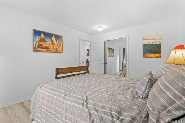 a bedroom with a bed and a painting on the wall