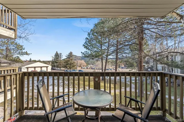a view of a balcony with chairs and wooden fence