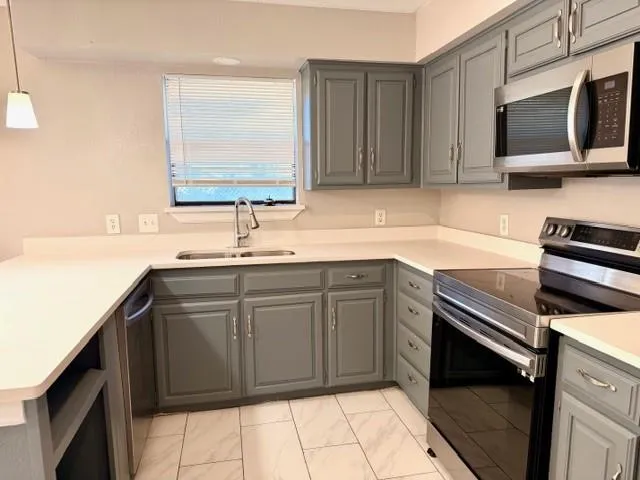 a kitchen with a sink a counter and windows