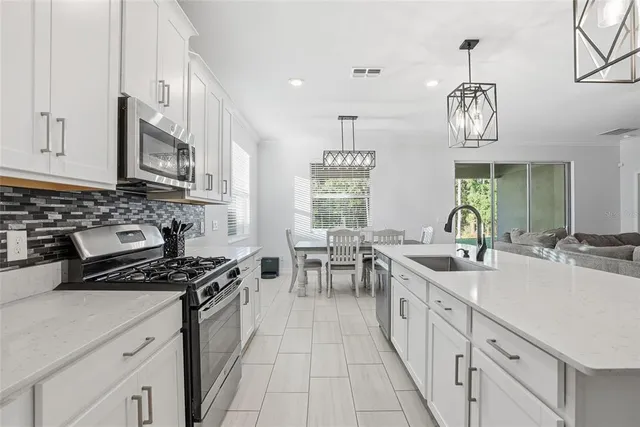 a kitchen with stainless steel appliances a sink stove and cabinets