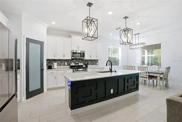 a kitchen with kitchen island granite countertop stainless steel appliances a sink stove and refrigerator